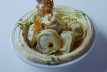 Hummus Topped With Varenikis And Fried Onions