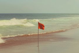 photo of one red flag on a beach
