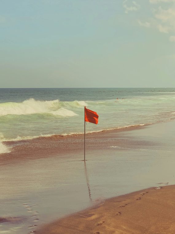 photo of one red flag on a beach